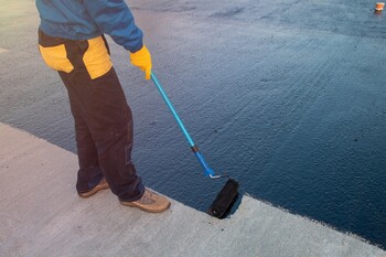 Roofer applying roof coating in Worden, MT